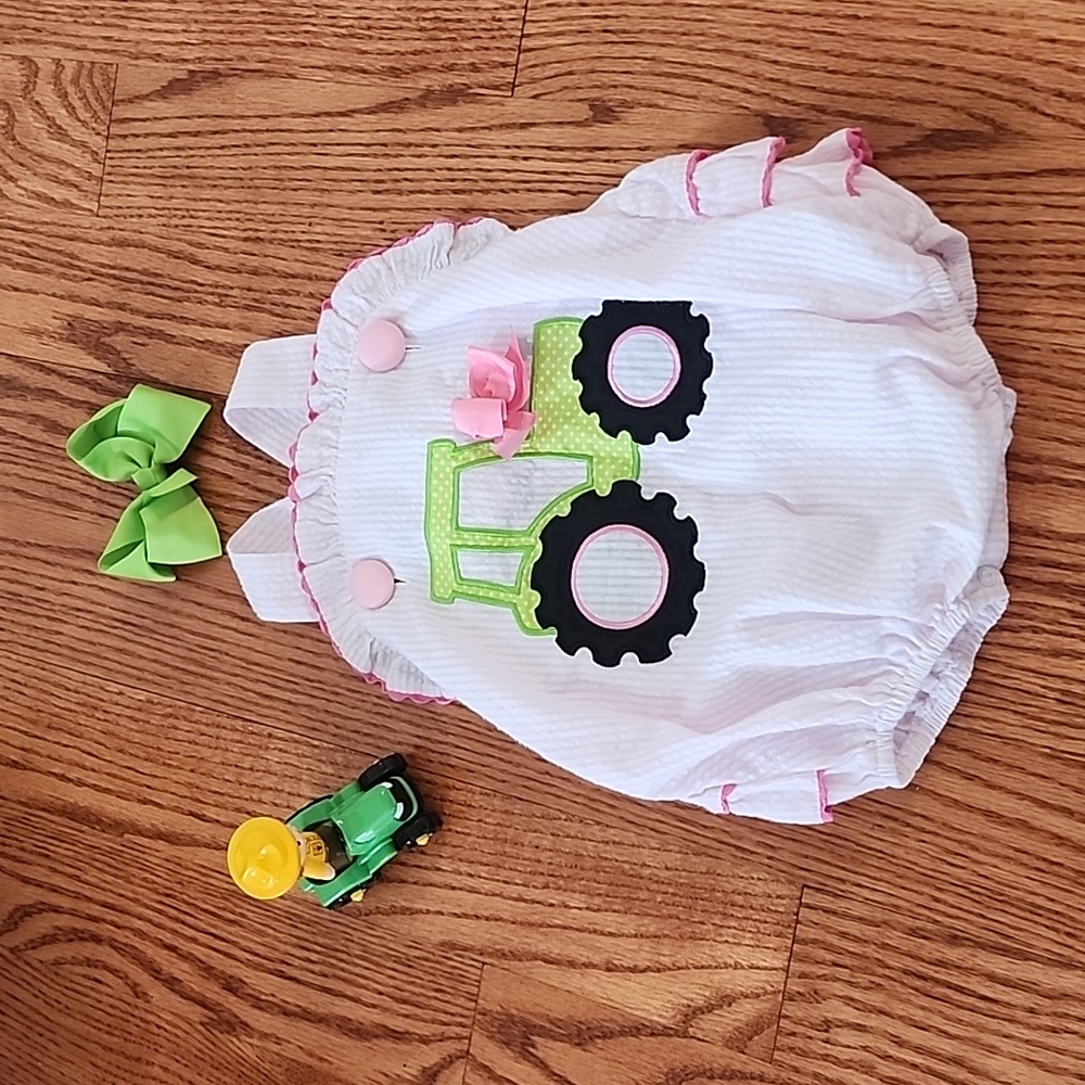 12 month tracter bubble suit. Banana split. Toy and bow included